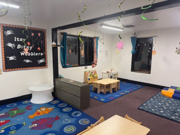 Kindergarten teacher teaching three kids to read